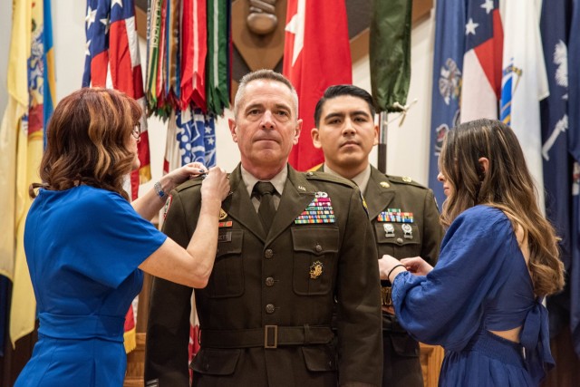 Col. Sean Crockett, U.S. Army Chemical, Biological, Radiological and Nuclear School commandant, has his brigadier general rank pinned on by his wife, Natalie (left), and his daughter, Savannah, during a promotion ceremony on Tuesday in Lincoln Hall Auditorium. 