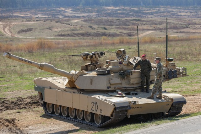 From left, Polish Maj. Gen. Adam Joks and U.S. Army Col. Ken Braeger speak while standing on top of an M1A2 Abrams tank as part of the Abrams Operations Summit at Bucierz Range, Drawsko Pomorskie, Poland, April 28, 2022. 