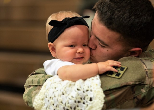 Spc. Dallas Ochoa, assigned to the 2nd Infantry Brigade Combat Team, 4th Infantry Division, reunites with his daughter, Kaylynn, following a homecoming ceremony at William Bill Reed Special Event Center, Fort Carson, Colo., Nov. 13, 2018.