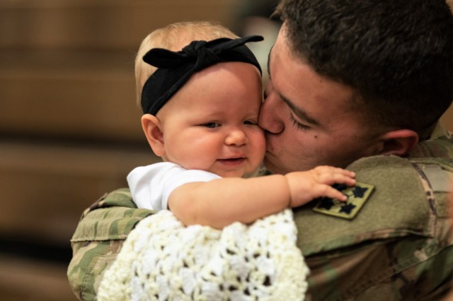 Spc. Dallas Ochoa, assigned to the 2nd Infantry Brigade Combat Team, 4th Infantry Division, reunites with his daughter, Kaylynn, following a homecoming ceremony at William Bill Reed Special Event Center, Fort Carson, Colo., Nov. 13, 2018.