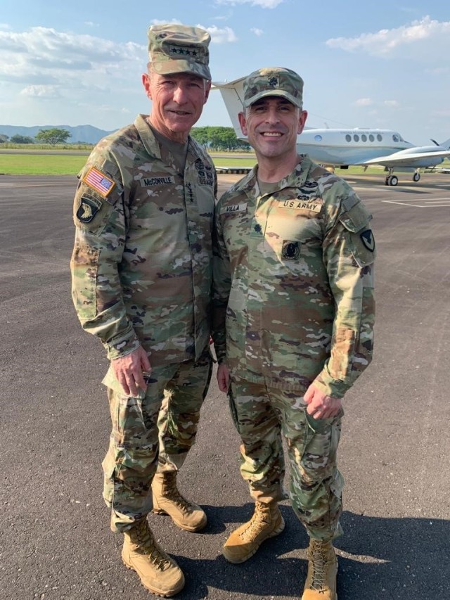 The 40th Chief of Staff of the Army, Gen. James C. McConville, visited Deputy Commander of the Colombian Army Maj. Gen. Juan Vicente Perez Duran at Tolemaida Air Base, Colombia on Jan. 30, 2023.  While there, McConville (left) met with U.S. country teams and presented a coin of appreciation to Lt. Col.  Adrian Villa  (right) for his work building partner capacity in South America. Villa leads the aviation technical assistance field team for the U.S. Army Security Assistance Training Management Organization (SATMO). A critical component of U.S. foreign policy, SATMO forms, trains, and employs security assistance teams tasked with increasing partner capability and capacity worldwide to meet Geographic Combatant Command requirements.