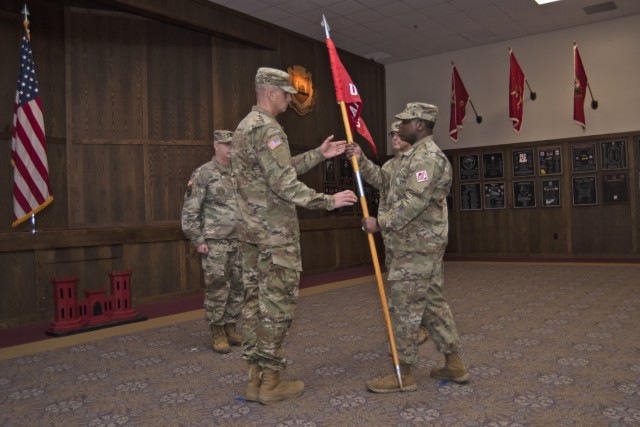 Chief Warrant Officer 5 Willie Gadsden Jr., U.S. Army Prime Power School commander, passes the school’s guidon to incoming 1st Sgt. Donald Cully as outgoing 1st Sgt. Mark Verry (second from right) looks on during a change-of-responsibility ceremony on Friday in the Engineer Regimental Room at the John B. Mahaffey Museum Complex. 