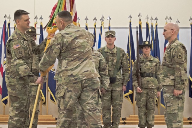 Incoming 14th Military Police Brigade Command Sgt. Maj. Charles Neikirk (left) accepts the unit guidon from Col. Kirk Whittenberger, 14th MP Bde. commander, as outgoing Command Sgt. Maj. Paul DeSanto (right) looks on during a change-of-responsibility ceremony on Friday at the 795th MP Battalion headquarters. 