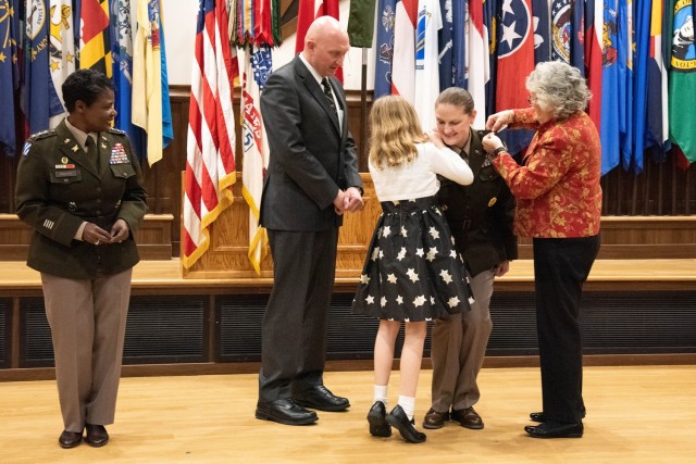 During a promotion ceremony on Jan. 26 in Lincoln Hall Auditorium, Col. Sarah Albrycht, U.S. Army Military Police School commandant (second from right), has her brigadier general rank pinned on by her husband, Robert Rossi, mother, Mary Dermody, and daughter, Catherine, as the Army Inspector General – and presiding officer for the ceremony – Lt. Gen. Donna Martin (left) looks on. 