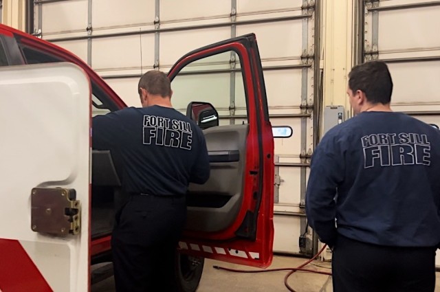 Fort Sill firefighters Christopher Webster and Taylor Bivona inspect vehicle. 