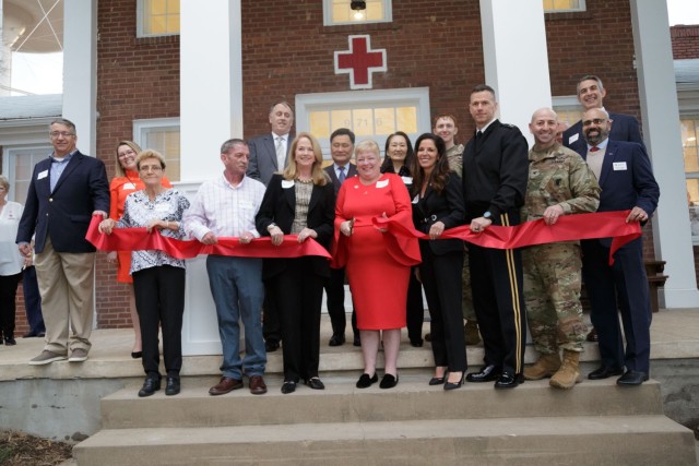 MG Allan Pepin, Commanding General, US. Army Military District of Washington, and Commander, Joint Force Headquarters-National Capital Region, right, and Col. Joseph Messina, Fort Belvoir Garrison Commander, assist with the ribbon at the Red Cross Carl H. McNair Jr. House, Jan 26, as Courtney McNair Bulger, Red Cross Executive Director in the National Capital Region, center, cuts the ribbon.