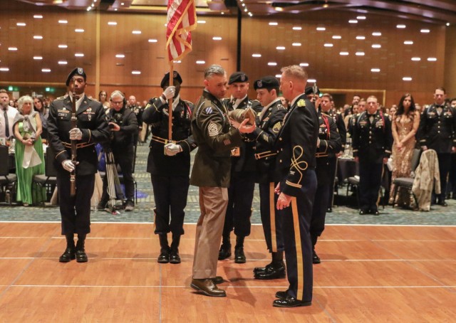 U.S. Army Command Sgt. Maj. Oracio Peña Jr. (front left) and Col. Kevin R. Sharp (front right) case the brigade colors with the 101st Airborne Division (Air Assault) Honor Guard during the Bastogne Ball Feb. 3, 2023, to signify upcoming deployment to the U.S. Army European Command area of operations.
