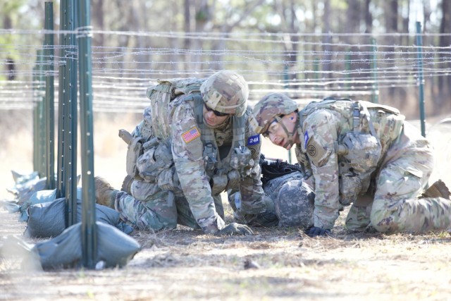 Sgt. Thomas Mulhern, left and Sgt. Klayton McCallum, both members of the New York Army National Guard's 2nd Battalion, 108th Infantry, move simulated casualty under a wire obstacles at the Army Best Medic Competition on January, 24, 2023 at Fort Polk Louisiana. The Two New York Army Guard Soldiers represented the Army National Guard during the competition. ( U.S. Army Photo by Sgt. Terry Vongsouthi)