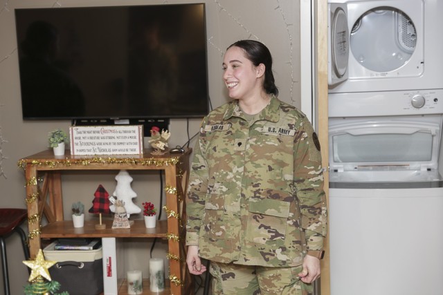SPC Emily Kirwan, with Fort Belvoir Community Hospital, speaks to a tour about living in the recently renovated enlisted Barracks, noting the increased safety that requires someone pass through three separate locks to access her room. She said she feels very safe living here and enjoys the in-room washer and dryer units as well.