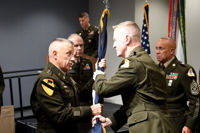  Brig. Gen. William Dyer, center right, passes the colors of the U.S. Army Reserve Legal Command to Lt. Gen. Stuart W. Risch, left, the 41st Judge Advocate General of the U.S. Army, as Brig. Gen. Gerald R. Krimbill, center left, looks on, during a change of command ceremony held October 21, 2022 at Arlington National Cemetery. Risch assumed leadership of USARLC during the ceremony which also saw Dyer promoted to Maj. Gen