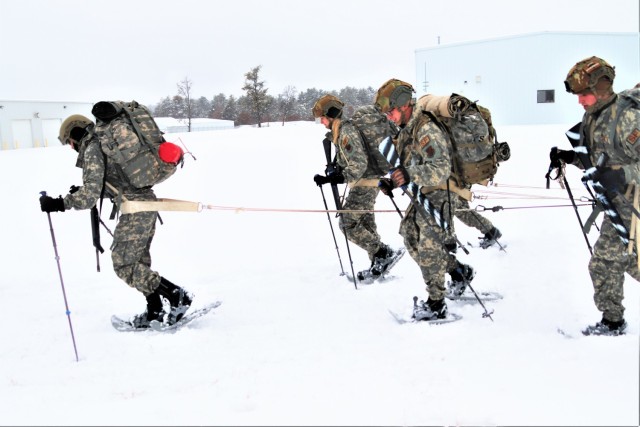Airmen with multiple Air National Guard security forces units learn squad tactics pulling an ahkio sled Jan. 19, 2023, as part of a 16-day Cold-Weather Operations Course led by the Air Force at Fort McCoy, Wis. More than 50 Airmen are participating in the training from across the Air Force. Besides learning about use of snowshoes and moving as a squad over terrain pulling an ahkio sled in a cold-weather environment, the Airmen also learned about cold-weather shelters, survival techniques, cold-weather uniform wear, and more. Fort McCoy has a long history of supporting cold-weather training. Eighty years prior to this training, in January 1943, the installation hosted winter training for the Army's 76th Division prior to the Division deploying to Europe to fight in the Battle of the Bulge in World War II. (U.S. Army Photo by Scott T. Sturkol, Fort McCoy Public Affairs Office)