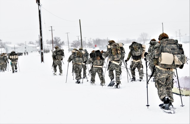 Airmen with multiple Air National Guard security forces units learn squad tactics pulling an ahkio sled Jan. 19, 2023, as part of a 16-day Cold-Weather Operations Course led by the Air Force at Fort McCoy, Wis. More than 50 Airmen were participating in the training from across the Air Force. Besides learning about use of snowshoes and moving as a squad over terrain pulling an ahkio sled in a cold-weather environment, the Airmen also learned about cold-weather shelters, survival techniques, cold-weather uniform wear, and more. Fort McCoy has a long history of supporting cold-weather training. Eighty years prior to this training, in January 1943, the installation hosted winter training for the Army's 76th Division prior to the Division deploying to Europe to fight in the Battle of the Bulge in World War II. (U.S. Army Photo by Scott T. Sturkol, Fort McCoy Public Affairs Office)