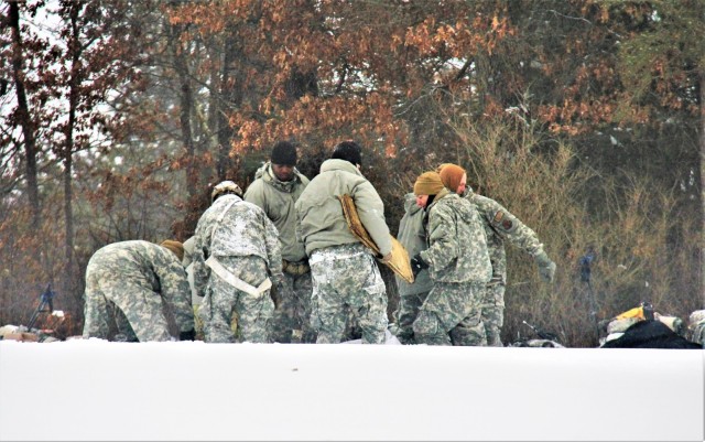 Airmen learn to build Arctic 10-person tents during cold-weather training at Fort McCoy