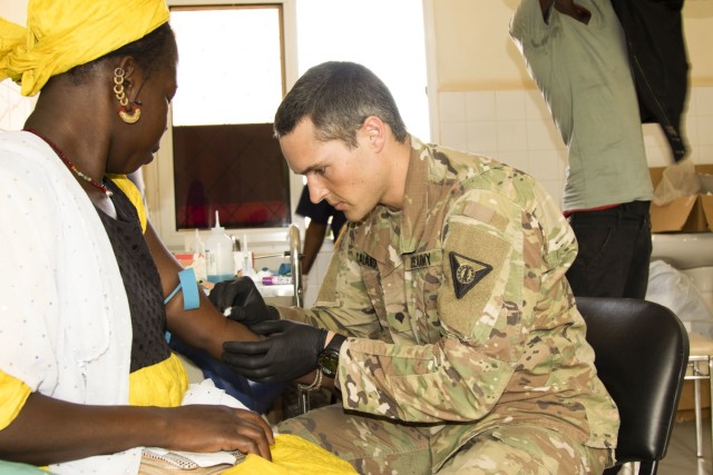 U.S. Army Spc. Joseph Calano, medic, Medical Detachment, Garrison Support Command, Vermont National Guard, draws blood from a patient at the Regional Center Hospital at Tambacounda, Senegal, on April 9, 2019. Vermont Guardsmen and their Senegalese...