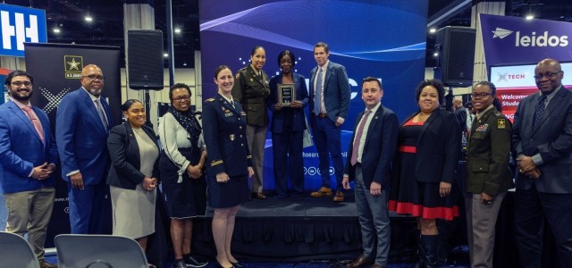 The xTechHBCU Student Competition’s second place winner (stage center), Lirane Mandjoupa, being presented with her award plaque by Dr. Matt Willis (stage center right), director, and LTC Sherida Whindleton (stage center left), deputy director, of Army prize competitions and the Army Applied SBIR Program. Competition judges (from left to right): Dr. Prabhat Kumar, Dr. Val Emery, Ms. Mich’a Gary, Dr. Adrienne Raglin, Maj. Katherine Carr, Ms. Charneta Samms, COL Alicia Johnson, and Dr. Reginald Hobbs. 