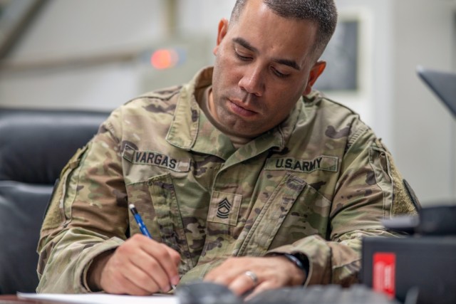 Master Sgt. Xavier Vargas, the noncommissioned officer in charge of the 369th Sustainment Brigade’s operations, documents discussions of those who competed in the brigade’s NCO and Soldier of the Quarter competition at Camp Arifjan, Kuwait, Dec. 21, 2022.