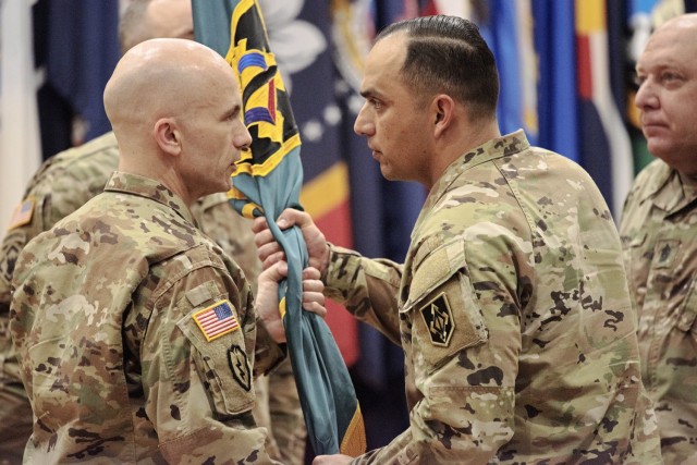Incoming Maneuver Support Center of Excellence NCO Academy Commandant Command Sgt. Maj. Paul DeSanto (left) accepts the MSCoE NCOA guidon from MSCoE and Fort Leonard Wood Command Sgt. Maj. Jorge Arzabala as outgoing MSCoE NCOA Commandant Command...