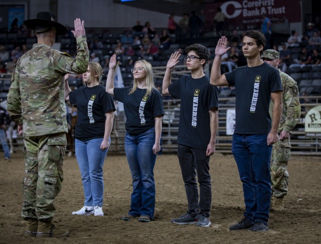 Director of the Mission Command Center of Excellence at Fort Leavenworth, Kansas, Brig. Gen. Jason Slider recites the Oath of Enlistment with four recruits at the Professional Armed Forces Rodeo in Topeka, Kansas, Oct. 22, 2022.
