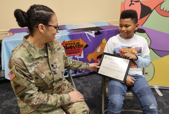 Scott Intermediate School student author Chance Brown shows his mother, Lt. Col. Carla Brown, the certificate he received from the Command and General Staff College honoring his achievement as a published author.