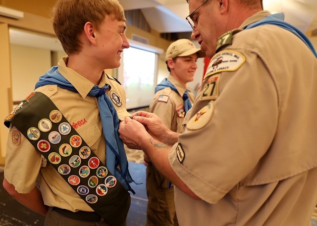 Scoutmaster of Troop 27, presents the Eagle Scout pin