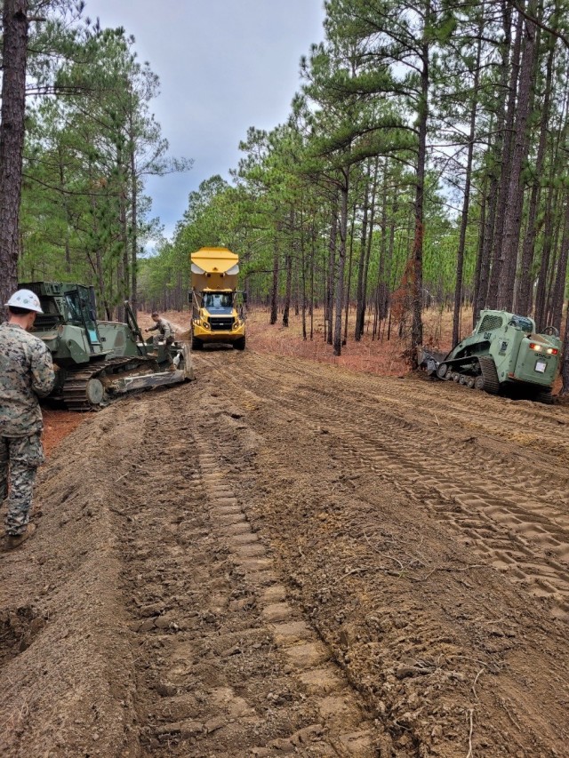 The Integrated Training Area Management and Range Control Office along with the 10th Marine Regiment Engineers stationed out of Camp Lejeune, North Carolina, work together to improve the firebreak, Feb. 24. The Integrated Training Area Management and Range Control Office formed a partnership with the 10th Marine Regiment Engineers stationed out of Camp Lejeune, North Carolina, to restore training land for maneuver and artillery fire. (U.S. Army photo by Darin Burns, Fort Bragg ITAM Office)