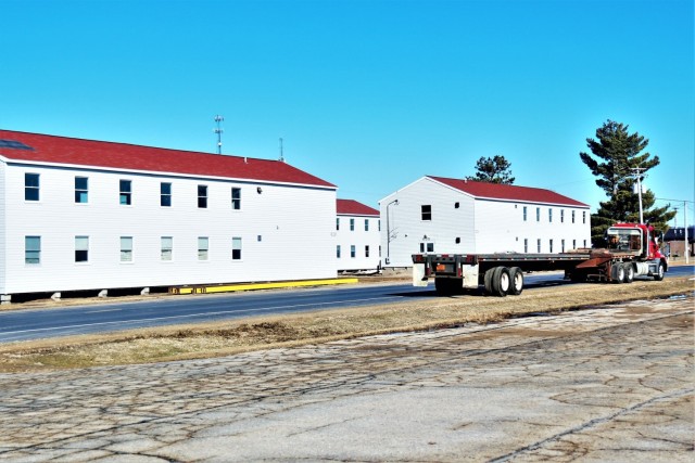 Contractors moving four World War II-era barracks buildings at Fort McCoy