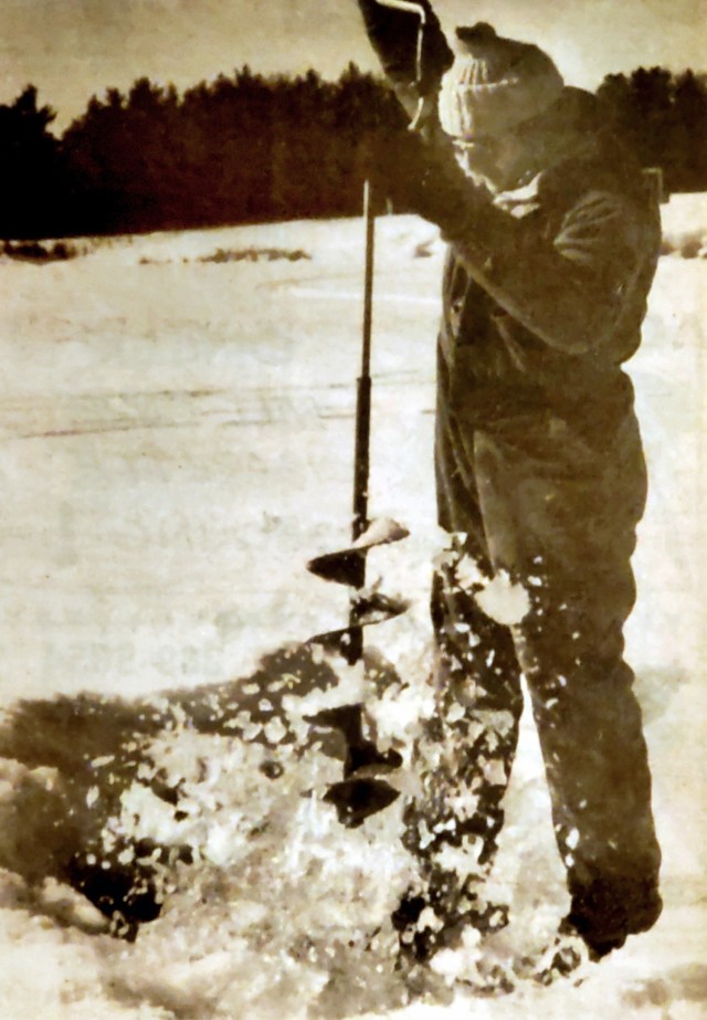 Fort McCoy community member Bob Macha uses an ice auger to drill a hole in the ice for ice fishing in February 1985 at what is now called Suukjak Sep Lake next to Pine View Campground at Fort McCoy, Wis. Macha was participating with others in a Fort McCoy ice fishing derby. (Photo by Mike Orrico/Fort McCoy Staff)