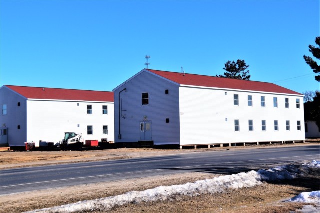 Contractors moving four World War II-era barracks buildings at Fort McCoy