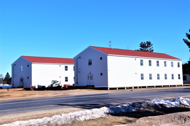 Contractors moving four World War II-era barracks buildings at Fort McCoy