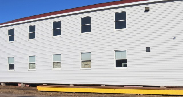 Contractors moving four World War II-era barracks buildings at Fort McCoy