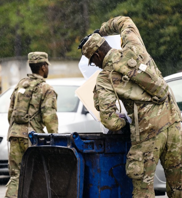 Soldiers dump documents containing personal identifiable information or PII into a dumpster to be shredded during America Recycles Day Nov. 15, 2022. The installation holds recycling and shred days routinely throughout the calendar year.
