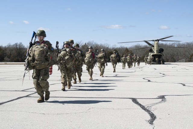 Trainees with Company E, 701st Military Police Battalion, de-board a CH-47 Chinook helicopter Saturday at Forney Airfield during the first of three field-training exercises in which they will participate during the 10-week basic combat training...