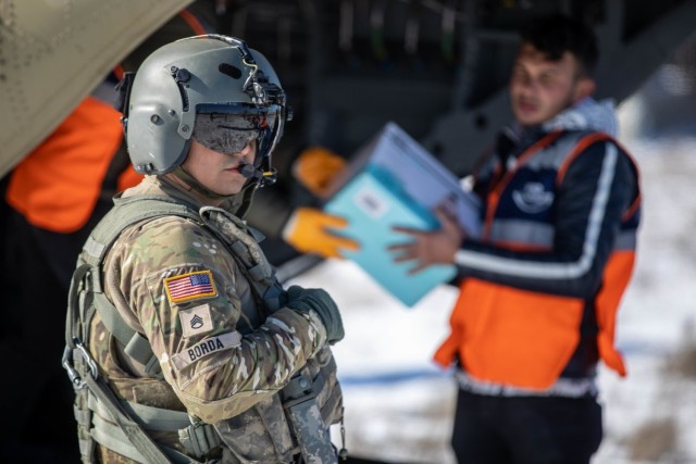 U.S. Army Staff Sgt loads humanitarian aid supplies