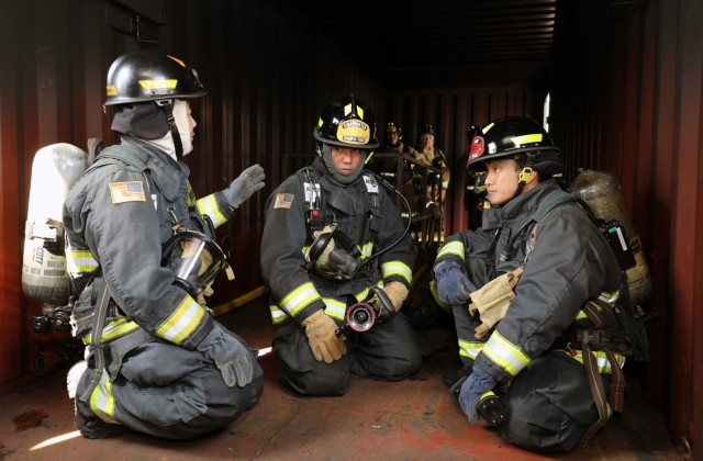 Masatoshi Sugiyama, left, training captain for the U.S. Army Garrison Japan fire department, briefs firefighters before they conduct a scenario inside a new live-fire training facility at Sagami General Depot, Japan, March 9, 2023. After being trained by contractors on the facility earlier this year, the USAG Japan fire department has recently begun to train its own personnel on the proper ways to handle indoor fires.