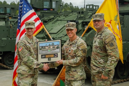 Lt. Col. Nate Costa, Product Manager, Armored Multi-Purpose Vehicles, presents an honorary plaque to Lt. Col. Stoney Portis, 3-69AR Battalion Commander and Command Sgt. Maj. Andrew O’Dell, 3-69AR Battalion Command Sergeant Major, to symbolize the completion of the first unit equipped. 
