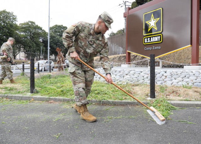 Pvt. Keith Tourtillott, assigned to the 901st Military Police Detachment, sweeps away debris from a sidewalk near the front gate at Camp Zama, Japan, March 14, 2023. Camp Zama personnel have been beautifying the entire installation this week in advance of this year’s first open-post event. 