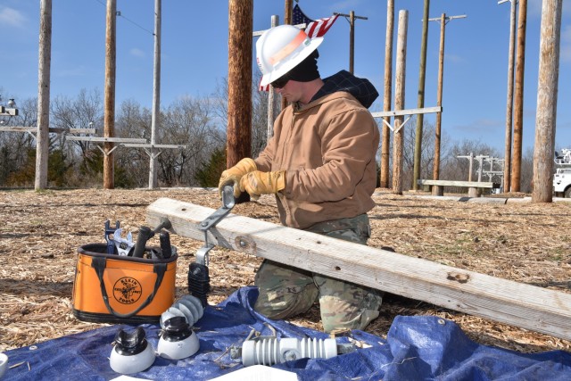 Powerline Distribution Course student, Sgt. Ethan Cavanaugh, builds a crossarm on the ground as part of the Lineman Rodeo at the U.S. Army Prime Power School on Fort Leonard Wood.
