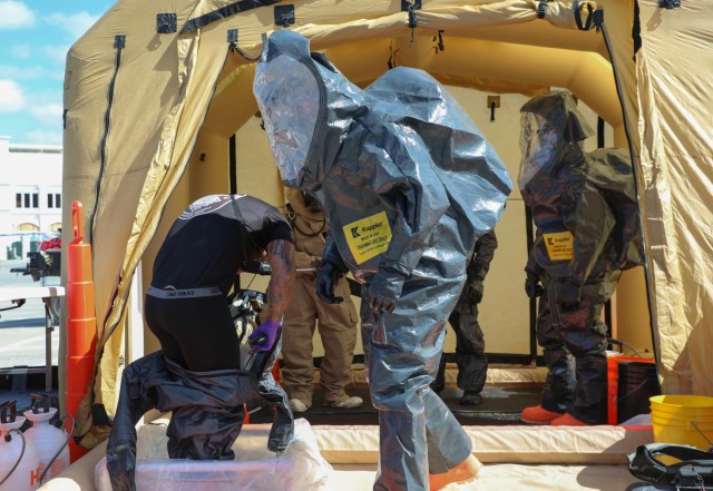 An officer with Louisville Metro Police&#39;s Hazardous Incident Response Team gets out of his hazardous material suit after working a simulated scenario with the help of Sgt. 1st Class Daniel Dormbrusch, 12th CST, New Hampshire National Guard, during a training event at Churchill Downs in Louisville, Ky., March 13, 2023. National Guard CSTs from eight states participated in the exercise. (U.S. Army National Guard photo by Sgt. 1st Class Benjamin Crane)