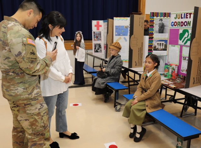 Addison Nguyen, right, a fourth grader at Arnn Elementary School, recites her lines while dressed up as Juliette Gordon Low, the founder of Girl Scouts of the USA, during a living wax museum event in the school&#39;s cafeteria at Sagamihara Family Housing Area, Japan, March 17, 2023. More than 60 fourth graders participated in the event, which highlighted change makers from athletes, artists and authors to inventors, politicians, royalty and other trailblazers.