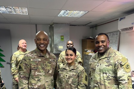Spc. Manal Munawar, an optical laboratory specialist assigned to the 384th Medical Logistics Company (Center) stands with Maj. Gen. Michel M. Russell Sr., commanding general of the 1st Theater Sustainment Command (Left) and Command Sgt. Maj. Albert E. Richardson Jr., command sergeant major of the 1st TSC (Right) during a battlefield circulation at the Al Udeid Air Base, Qatar.  Munawar serves as the U.S. Army Medical Materiel Center – Southwest Asia’s optical fabrication noncommissioned officer in charge. (U.S. Army Courtesy Photo)
