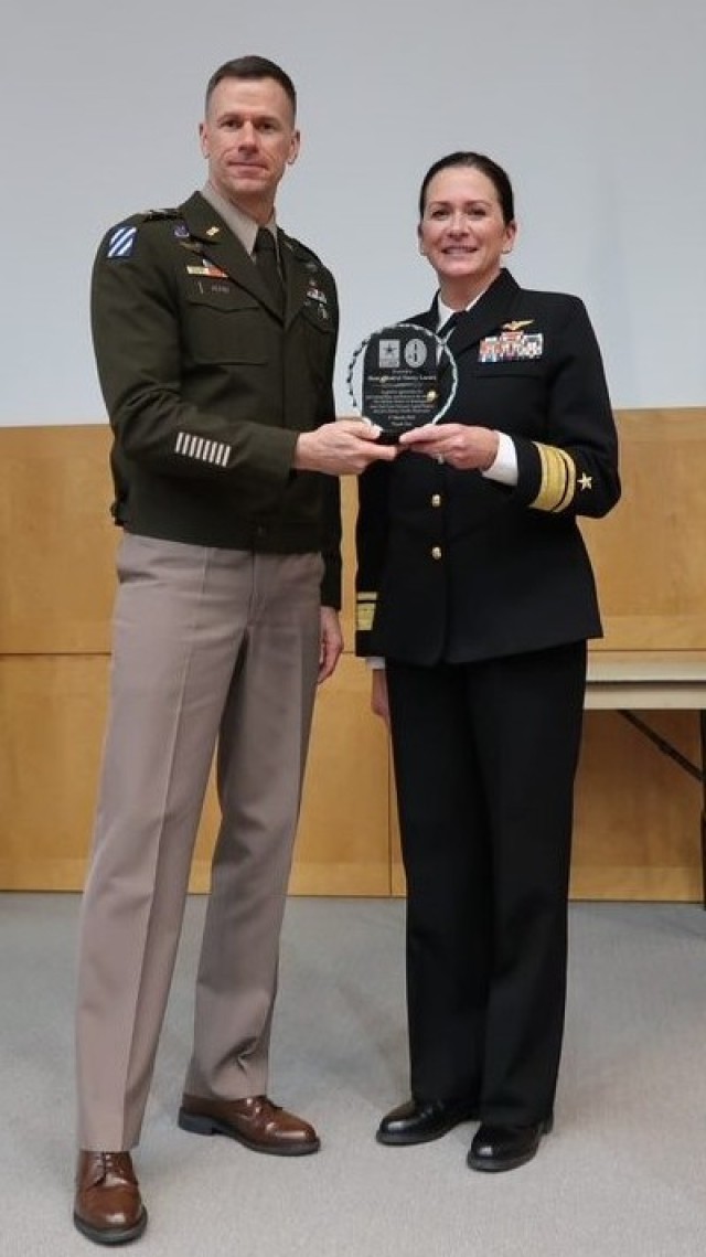 MG Allan Pepin, the JTF-NCR/MDW Commanding General, presents a gift of appreciation to RADM Nancy Lacore at the Women’s History Month observance hosted by the Joint Task Force-National Capital Region and the U.S. Army Military District of Washington at the National Defense University’s Lincoln Auditorium on Fort McNair, DC, Friday, March 17, 2023.