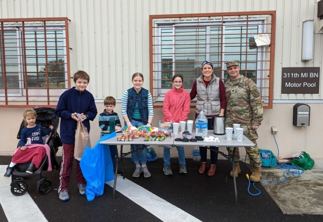 The Sikes family, whose members often volunteer in the community, hands out snacks and coffee at the 311th Military Intelligence Battalion&#39;s motor pool.