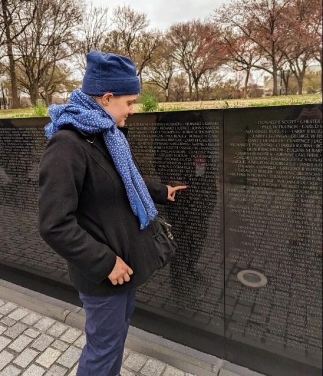 Maribel Sikes, a Camp Zama military dependent, points to the name of Navy Capt. Frank Fullerton as she visits the Vietnam Veterans Memorial wall in Washington, D.C., March 2023. Sikes won the Pacific areas level of an audio essay contest held by the Veterans of Foreign Wars organization, in which she mentioned Fullerton, an A-4F Skyhawk pilot who never returned from a mission over North Vietnam.