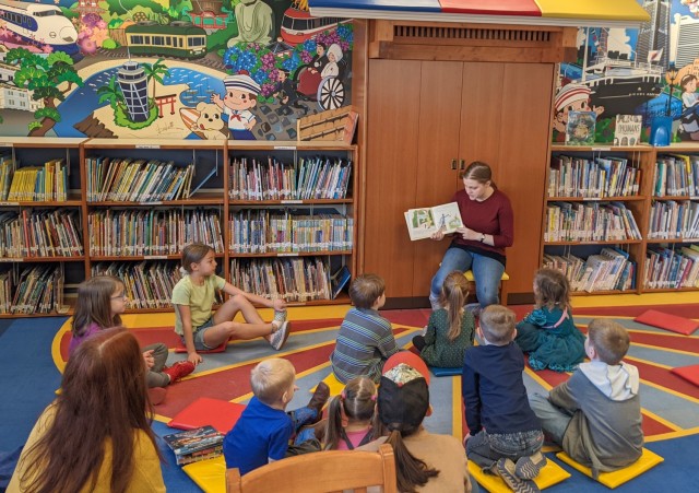 Maribel Sikes, a military dependent, reads to children inside the Camp Zama Library in Japan. Maribel, who often volunteers in the community, recently won the Pacific areas level of an audio essay contest held by the Veterans of Foreign Wars organization.