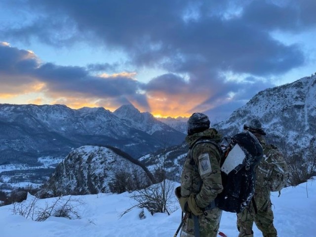 U.S. Army Soldiers from 3rd Battalion, 172nd Infantry Regiment (Mountain), 86th Infantry Brigade Combat Team (Mountain), watch the sun set over the mountains around Kolašin, Montenegro, on their descent from the summit during Common Challenge 23, Feb. 7, 2023. Common Challenge 23 is a multinational exercise focused on integrating allied forces and conducting mountain warfare operations in severe terrain and weather with military members from the United States, Montenegro, Austria, North Macedonia and Italy forming a multinational mountain infantry company.