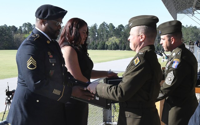 Staff Sgt. Trevor Ward receives his Retiree Commendation Package from Col. Carter Price, Army Training Center chief of staff, while his wife, Charidy Loeh, who works with AAFES on post, receives a Certificate of Appreciation from Army Chief of...