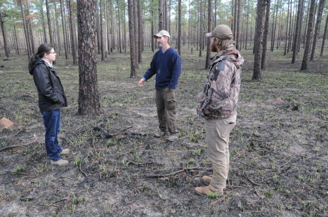 Rabung speaks with Chris Melder (center) and Christiansen about Red Cockaded Woodpecker conservation efforts on Fort Polk.