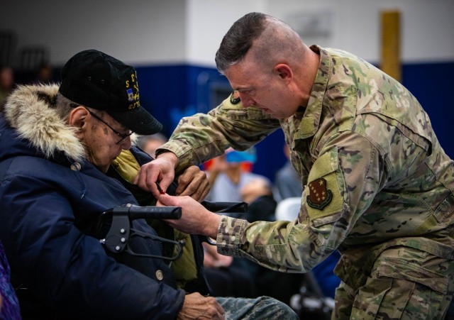 Maj. Gen. Torrence Saxe, adjutant general of the Alaska National Guard and commissioner of the Department of Military and Veterans Affairs, pins the Alaska Heroism Medal on Cpl. Bruce Boolowon, the only surviving member of the June 22, 1955, rescue team March 28, 2023, in Gambell, Alaska. The Alaska Heroism Medal is the state’s highest award for valor during peacetime.