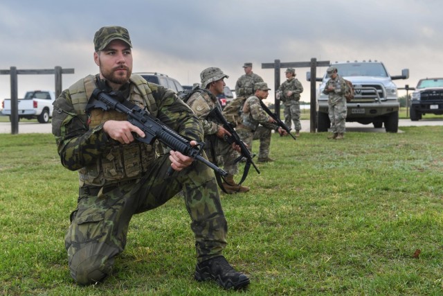 Staff Sgt. Maxim Mojzis, Czech army, kneels alongside Chilean armed forces in preparation for the M-4 qualifying event during the Texas Military Department Best Warrior Competition at Camp Swift, Texas, March 31, 2023. The friendly, six-day...