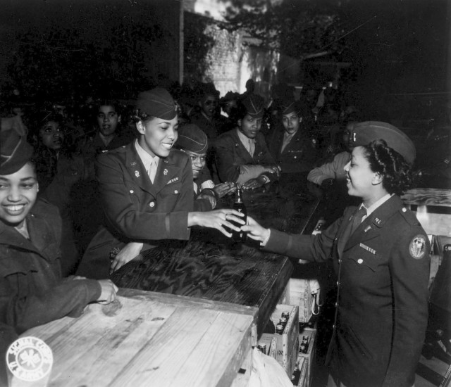 A member of the Women's Army Corps' 6888th Central Postal Directory Battalion serves the inaugural Coca-Cola to Army Maj. Charity Adams at the grand opening of the battalion's snack bar in Rouen, France, July 1, 1945. (U.S. Army photo)
